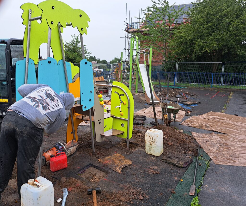 A contractor working on a piece of play equipment