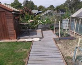 Strimmed grass, painted shed, new path and borders placed.
